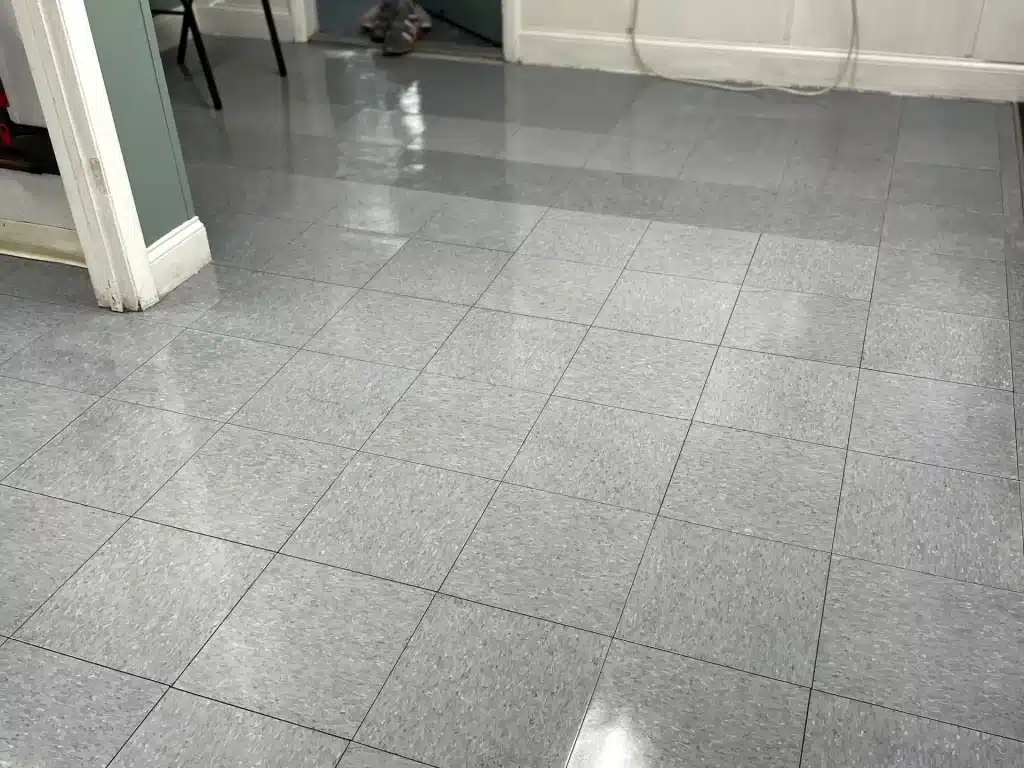 Commercial tile floor cleaning — reflective gray tile close-up