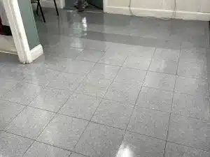 Commercial tile floor cleaning — reflective gray tile close-up