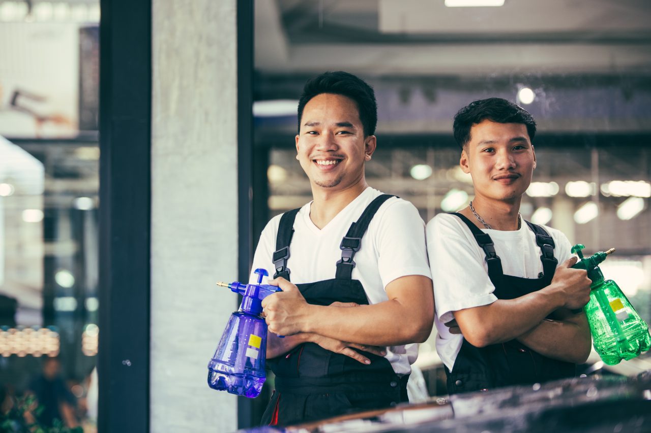 portrait of asian mechanic standing in arms crossed smiling to camera