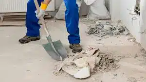 shoveling drywall rubble — construction clean up services; commercial construction cleaning